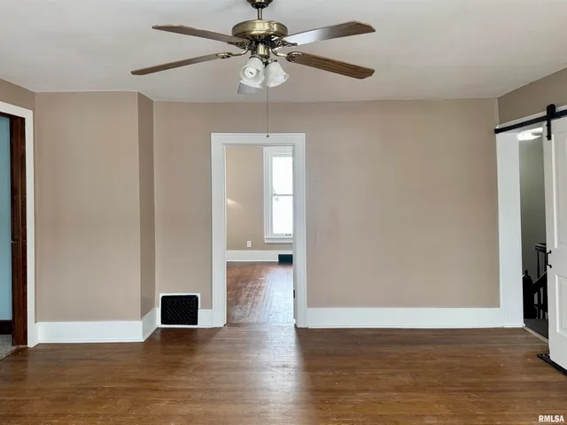a view of empty room with wooden floor