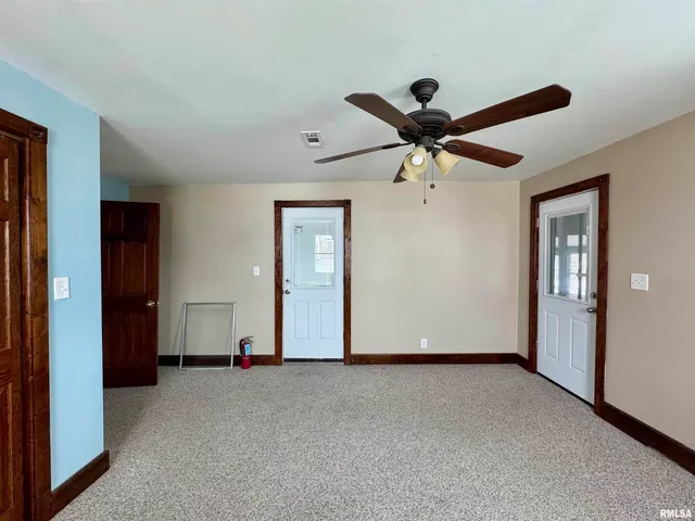 an empty room with closet and a ceiling fan