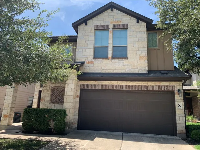 a front view of a house with plants