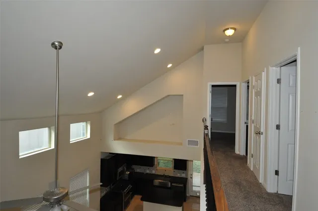 a view of a hallway to a room with windows