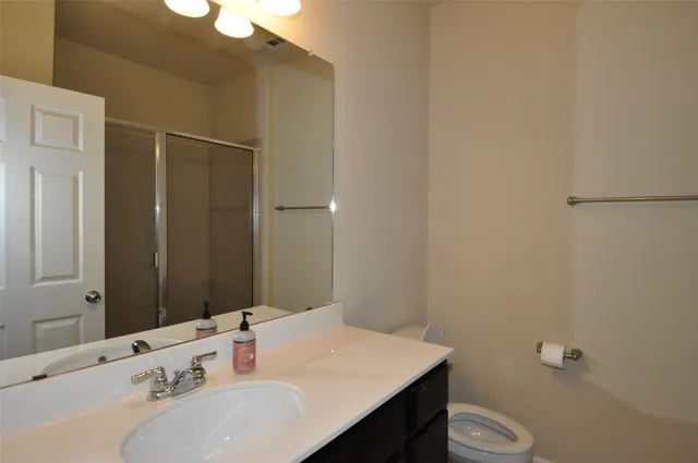 a bathroom with a sink a toilet and shower