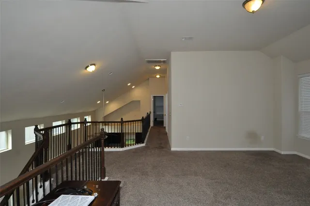 a view of staircase with lots of frames on wall and stairs