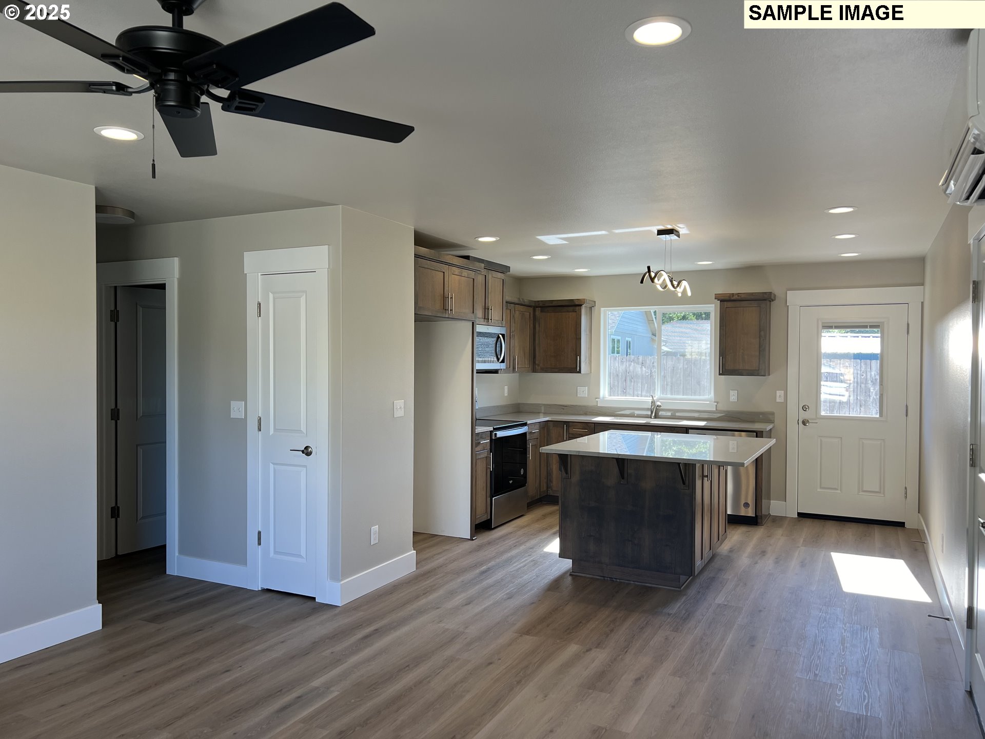 119 Lebleu Lane Winston, OR 97496 - Photo 3 of 30 a large kitchen with a center island wooden floor stainless steel appliances and windows