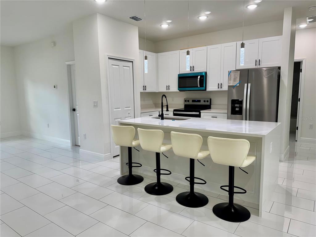 12970 Southwest 43rd Ave Road Ocala, FL 34473 - Photo 17 of 44 a kitchen with stainless steel appliances granite countertop a sink counter space and cabinets