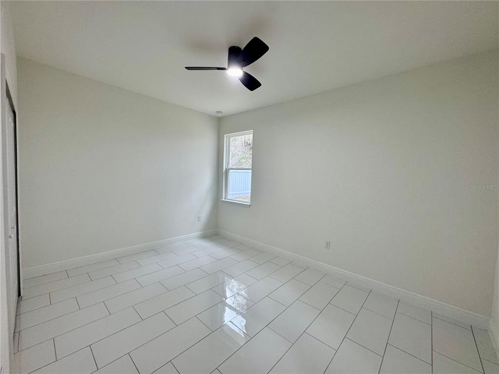 12970 Southwest 43rd Ave Road Ocala, FL 34473 - Photo 28 of 44 an empty room with view of ceiling fan and window