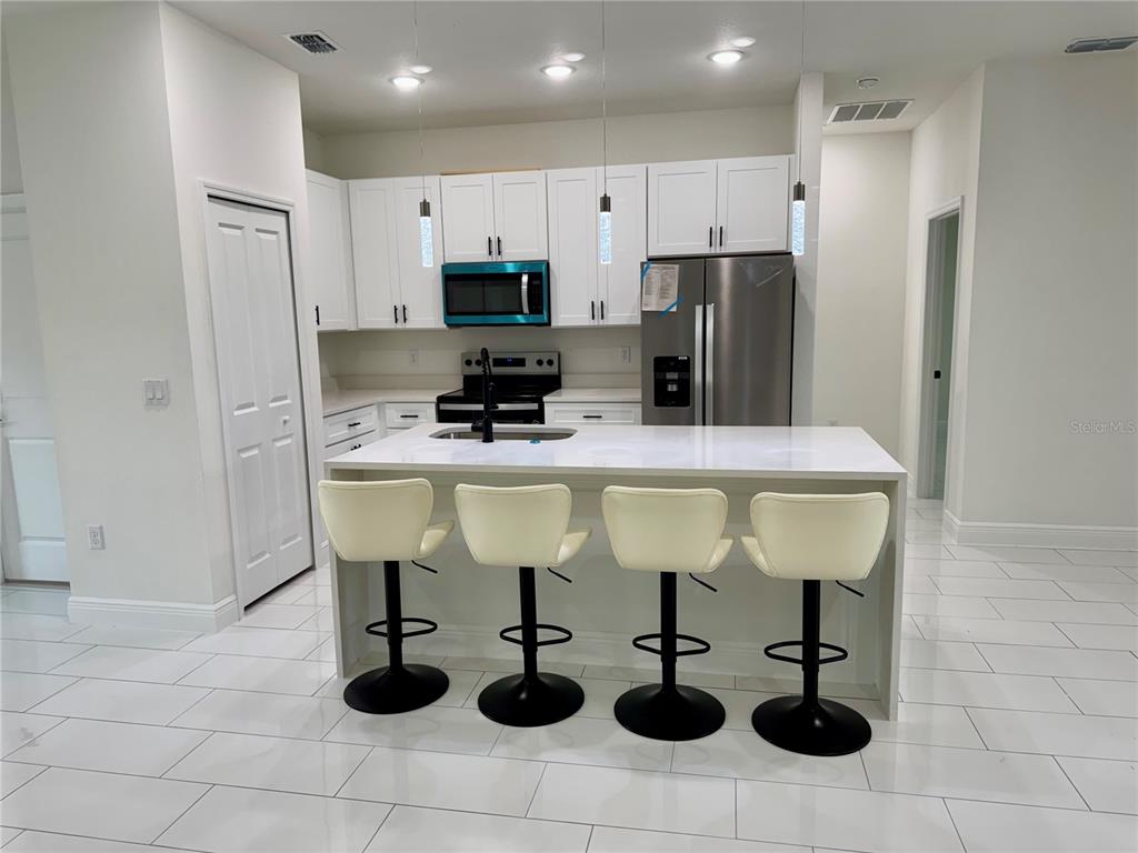 12970 Southwest 43rd Ave Road Ocala, FL 34473 - Photo 41 of 44 a room with stainless steel appliances kitchen island granite countertop a sink refrigerator and cabinets