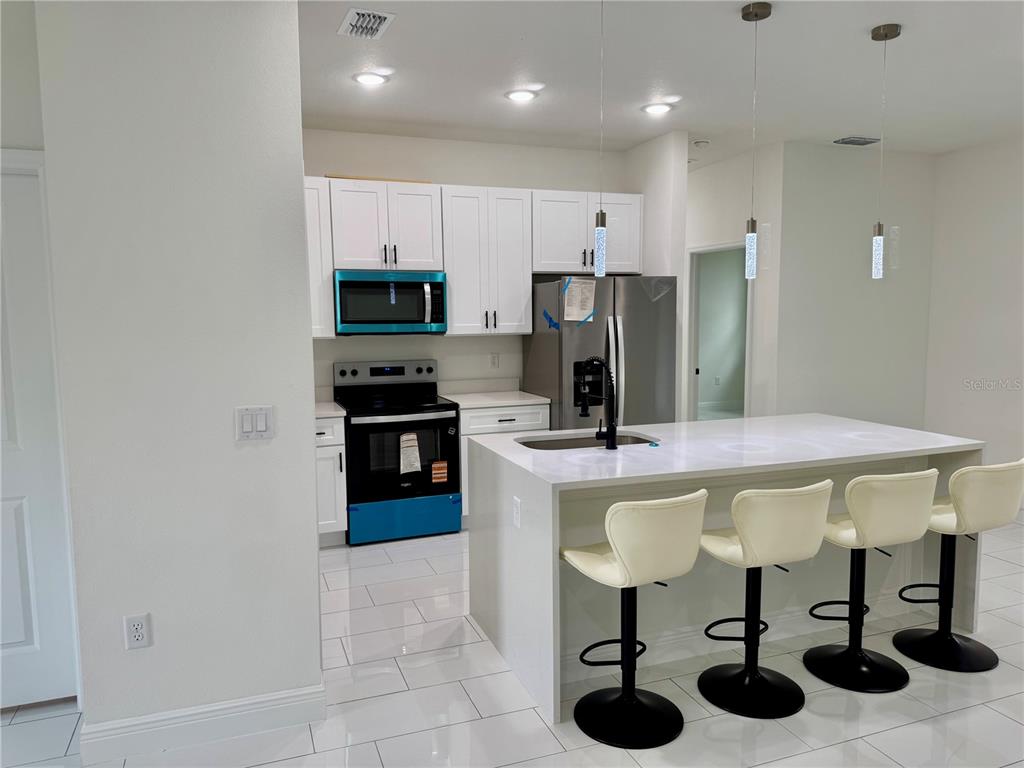 12970 Southwest 43rd Ave Road Ocala, FL 34473 - Photo 42 of 44 a kitchen with kitchen island stainless steel appliances a sink and cabinets