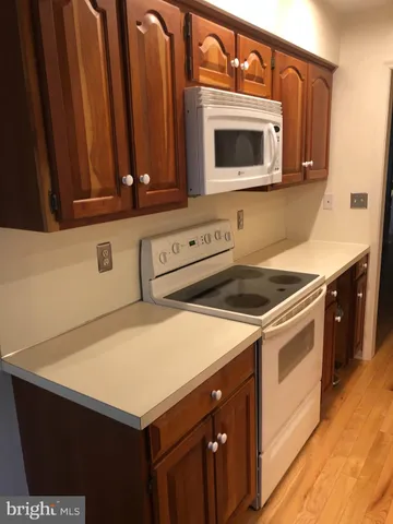 a kitchen with stainless steel appliances a stove a microwave and white cabinets