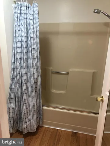 a bed sitting in a bedroom and wooden floor