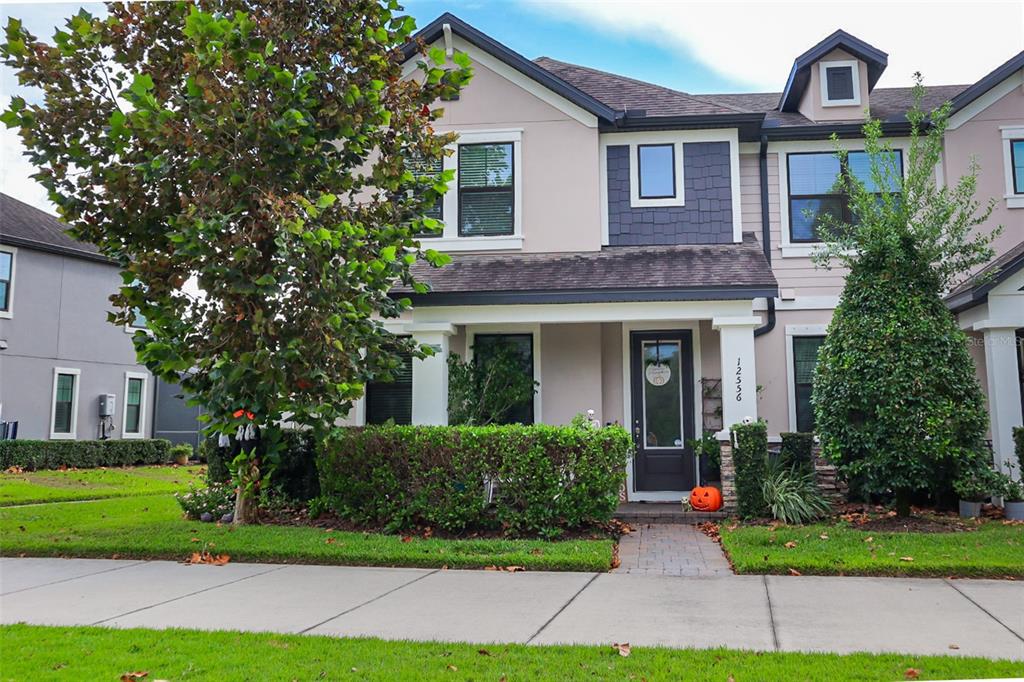 a front view of a house with a yard and potted plants