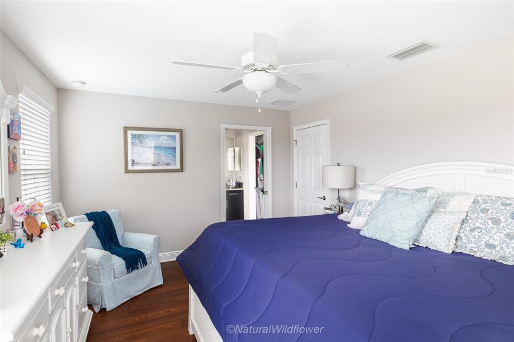 12556 Rangeland Boulevard Odessa, FL 33556 - Photo 19 of 29 a bedroom with a bed and a chandelier