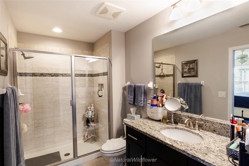 12556 Rangeland Boulevard Odessa, FL 33556 - Photo 20 of 29 a bathroom with a granite countertop sink toilet and shower