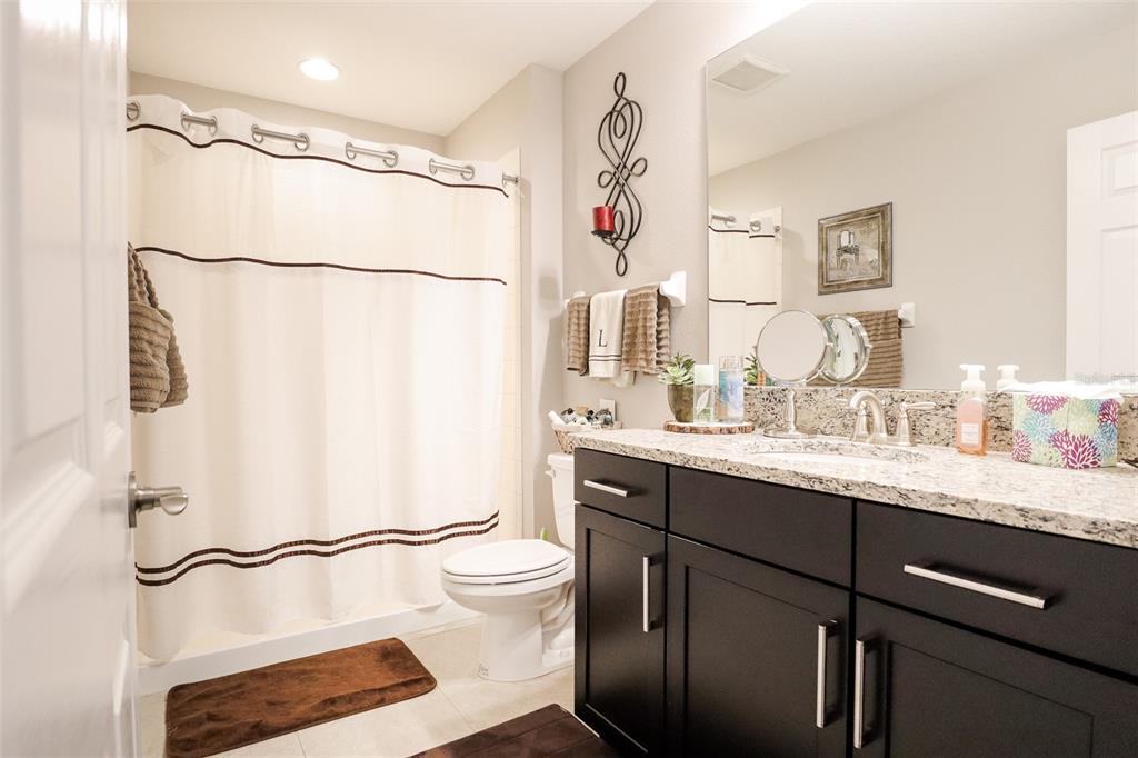 12556 Rangeland Boulevard Odessa, FL 33556 - Photo 20 of 27 a bathroom with a granite countertop sink and a mirror