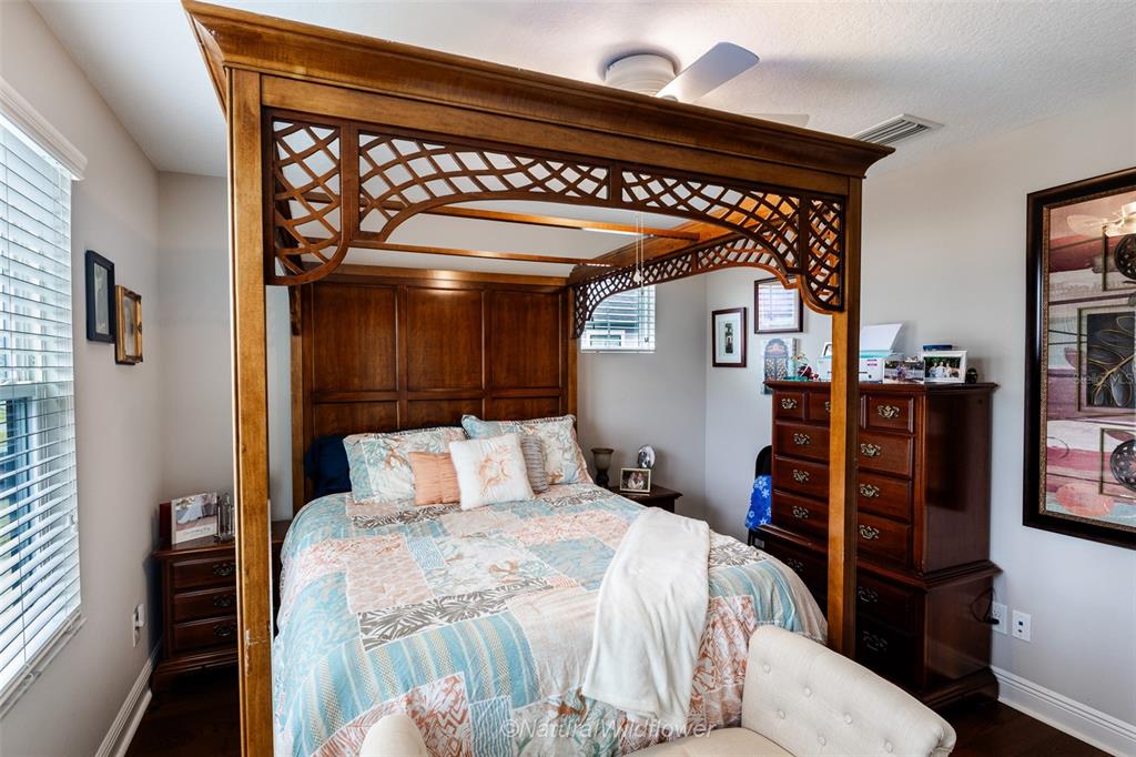 12556 Rangeland Boulevard Odessa, FL 33556 - Photo 23 of 29 a bedroom with a large bed and a chandelier
