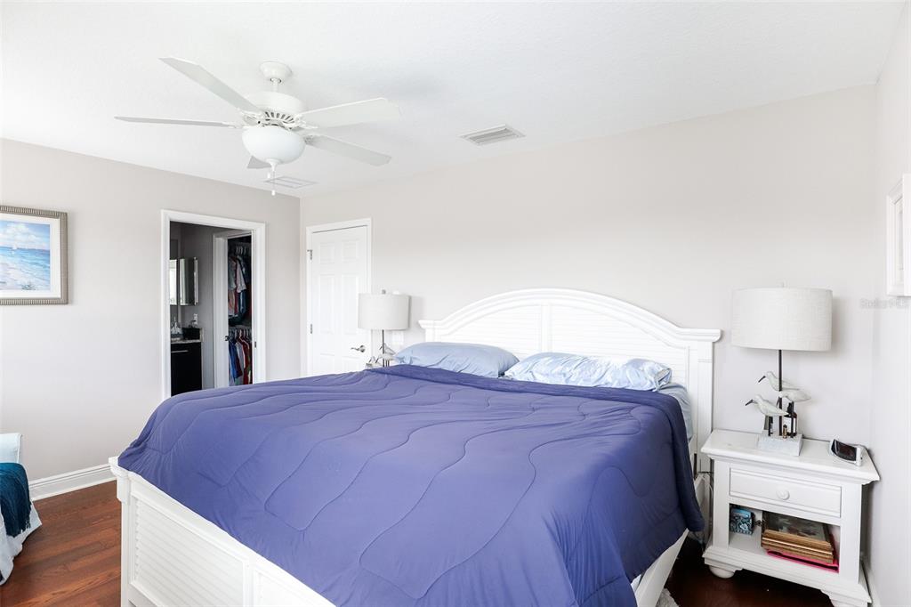 12556 Rangeland Boulevard Odessa, FL 33556 - Photo 24 of 27 a spacious bedroom with a bed and a lamp