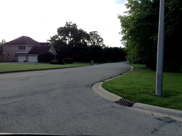a view of a street with a house in the background
