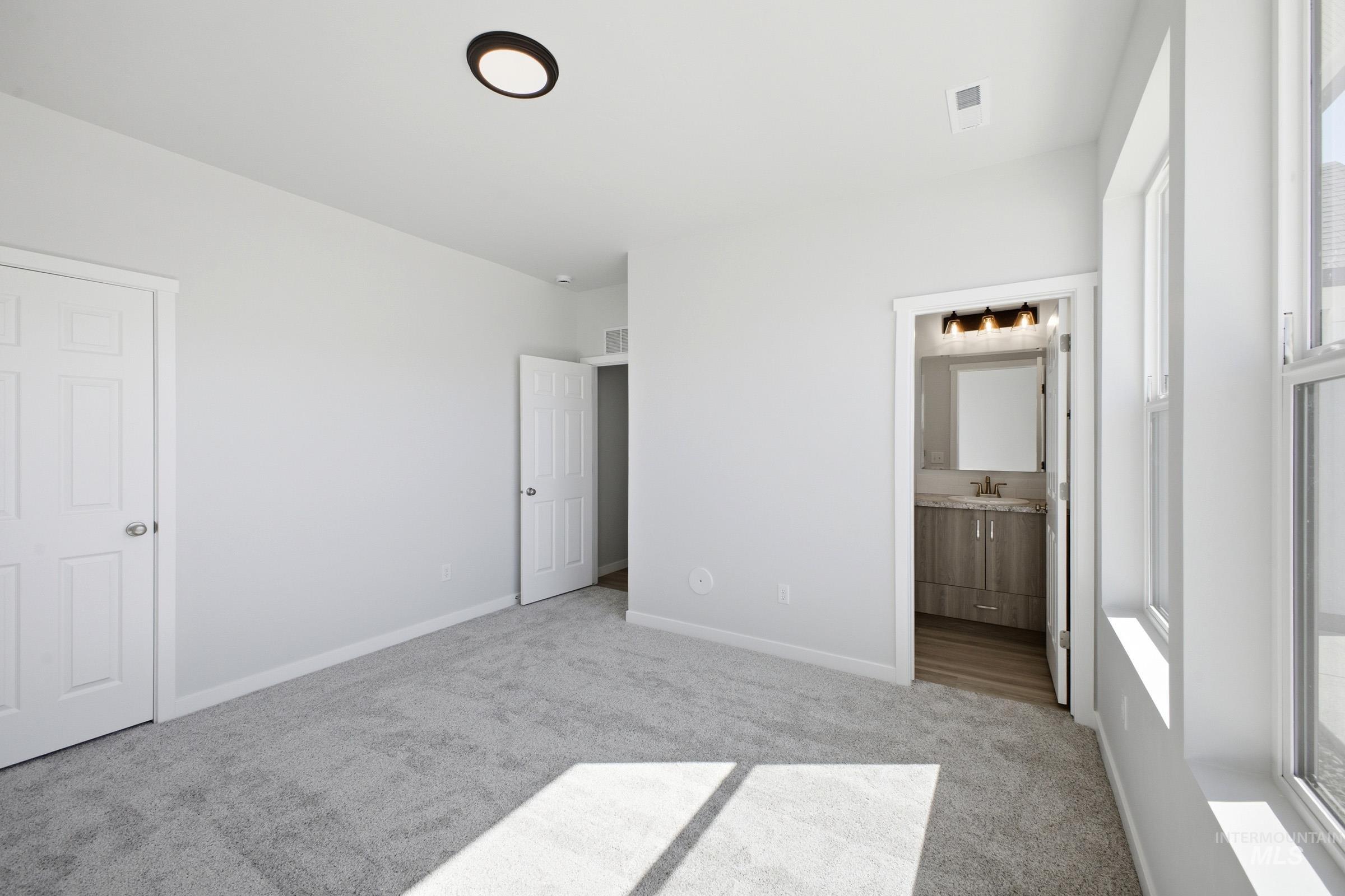 13633 Redway Court Caldwell, ID 83607 - Photo 20 of 29 Unfurnished bedroom featuring light colored carpet and connected bathroom