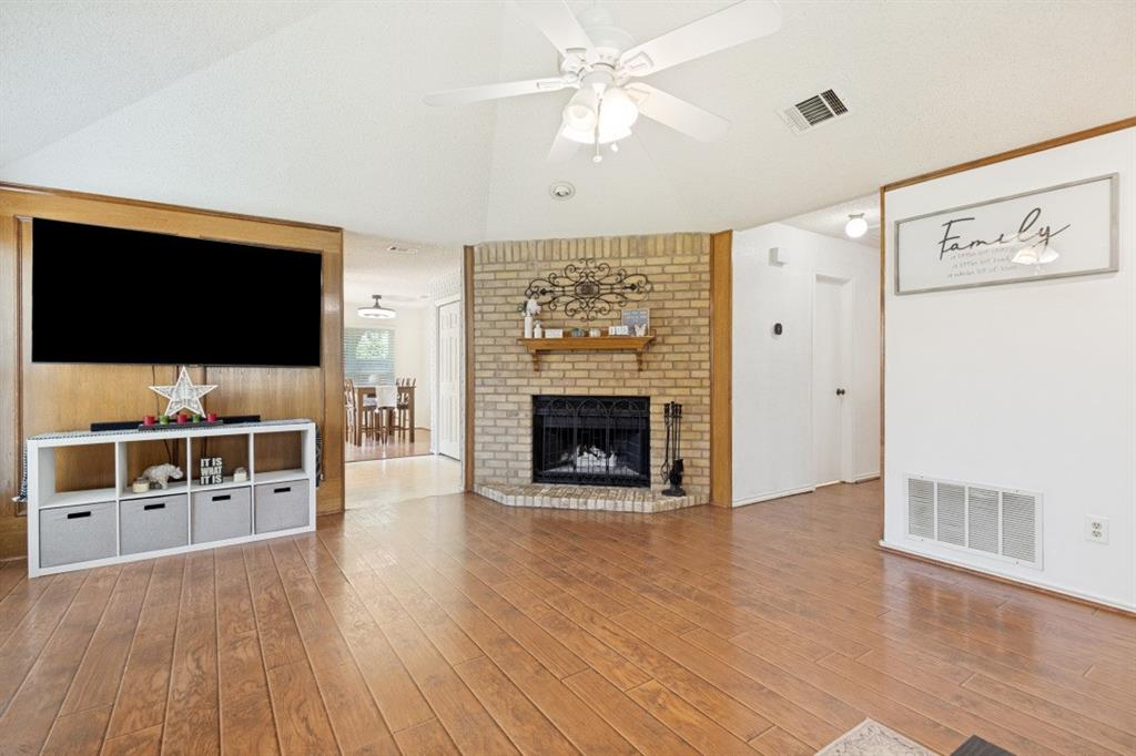 7410 Jessica Way Rowlett, TX 75088 - Photo 8 of 25 a living room with furniture a flat screen tv and a fireplace