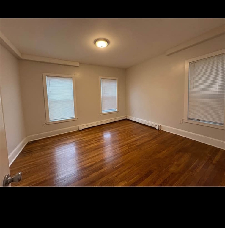 721 Broadway, Unit 2 Chelsea, MA 02150 - Photo 2 of 3 a view of empty room with wooden floor and fan
