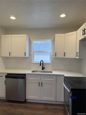 a kitchen with white cabinets appliances and sink