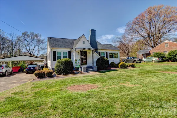 a front view of a building with cars parked
