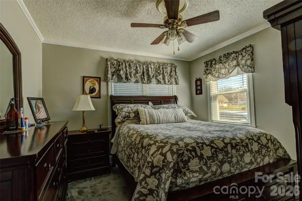 a bedroom with a bed and a flat tv screen on dresser