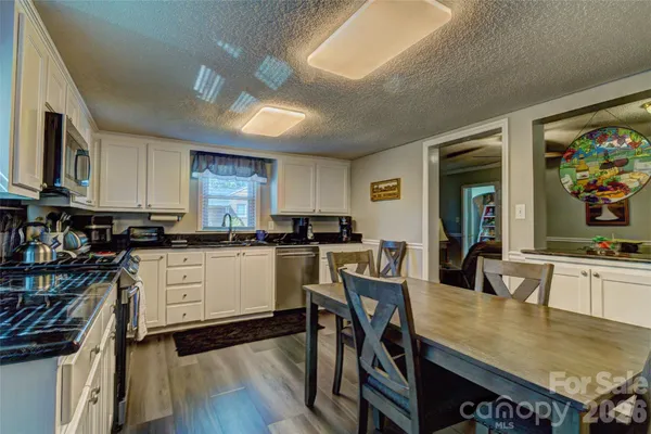 a kitchen with a table chairs stove and cabinets