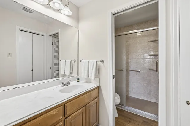 a bathroom with a shower sink vanity and mirror