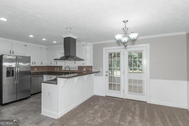 a kitchen with stainless steel appliances granite countertop a stove and cabinets