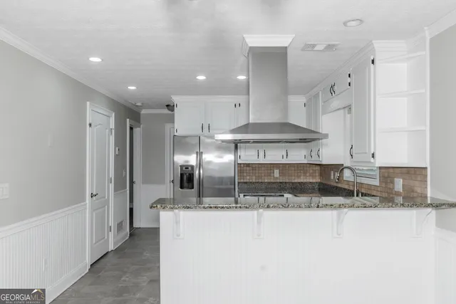 a kitchen with stainless steel appliances granite countertop a sink a stove and a refrigerator