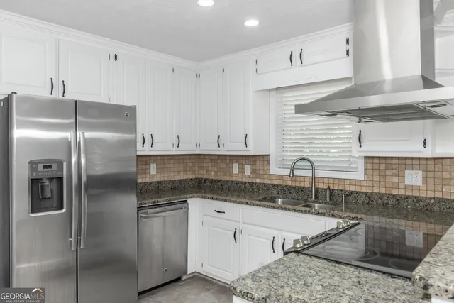 a kitchen with stainless steel appliances granite countertop a sink refrigerator and cabinets