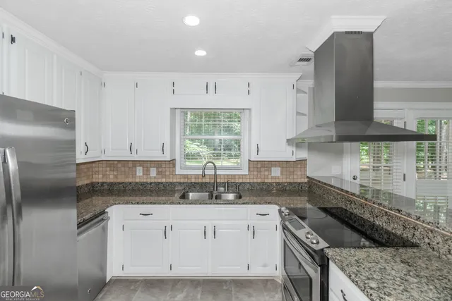 a kitchen with granite countertop white cabinets and white appliances