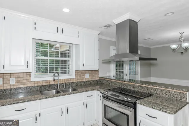 a kitchen with granite countertop a sink stove and cabinets