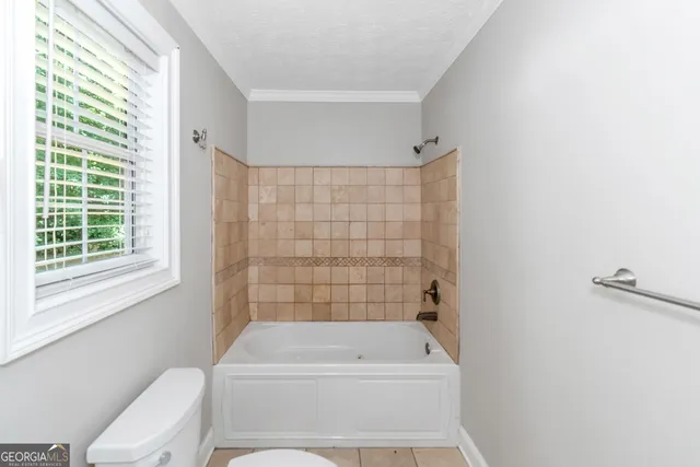 a bathroom with a toilet a bath tub and a shower