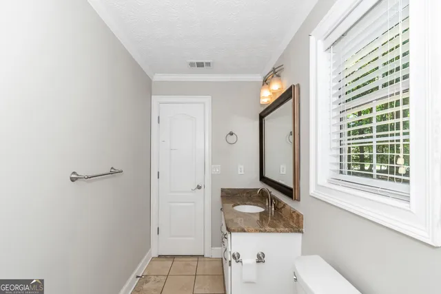 a bathroom with a toilet sink and mirror