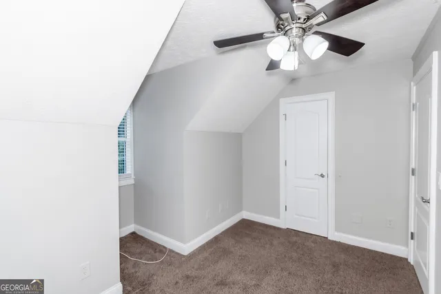 an empty room with a ceiling fan and a fan