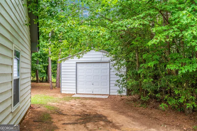 a backyard of a house with large trees and brick walls