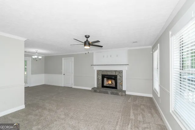 an empty room with windows and fireplace