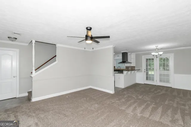 a view of kitchen and empty room with cabinet