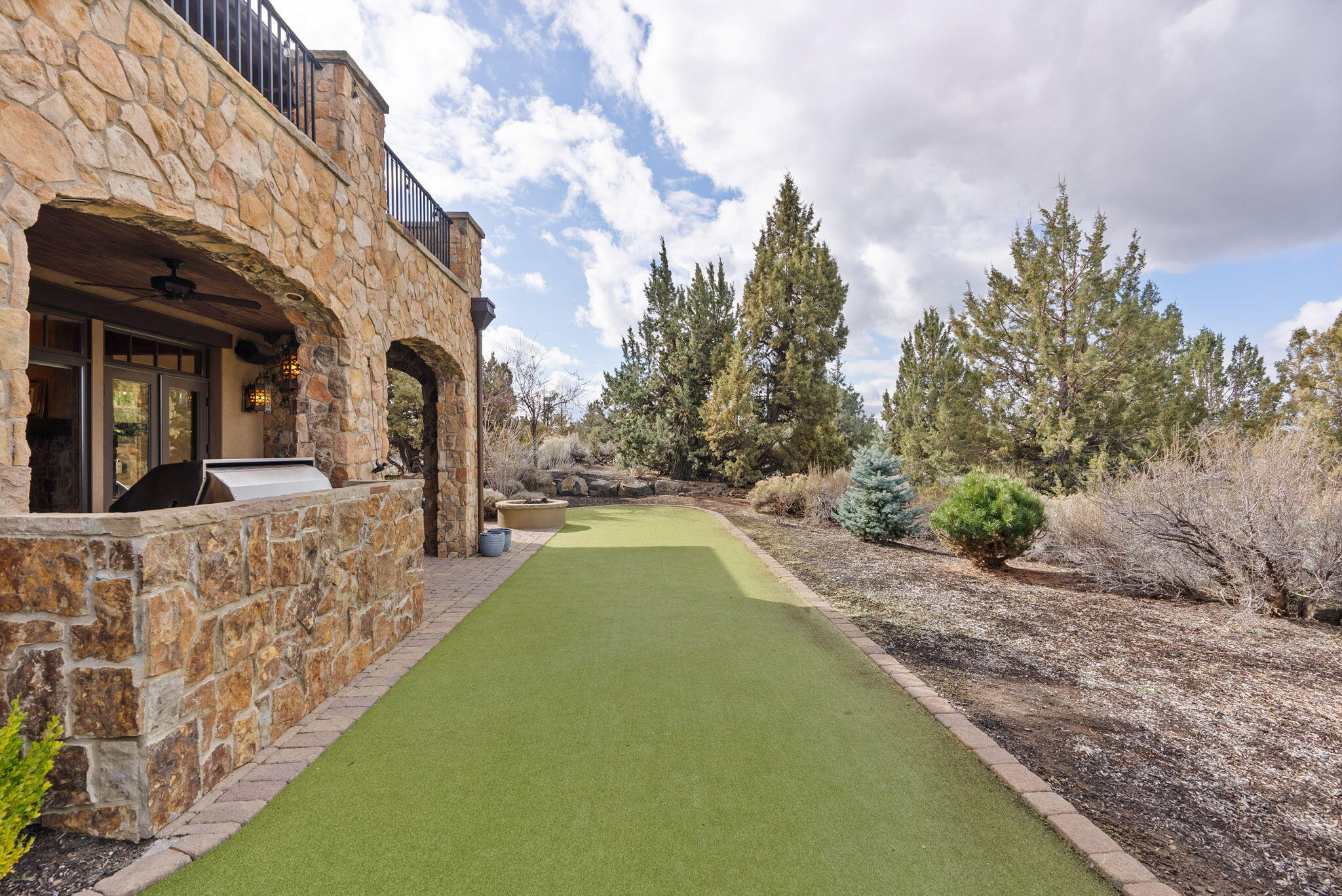22887 Ghost Tree Lane Bend, OR 97701 - Photo 32 of 97 Enjoy the mountian views from the rear paver patio complete with gas firepit, outdoor kitchen and putting green/bocceball court