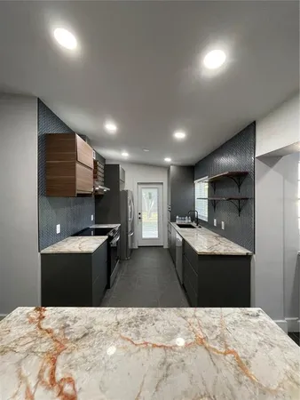 a kitchen with kitchen island sink stove and refrigerator