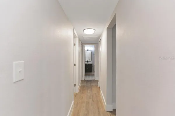 a view of a hallway with wooden floor
