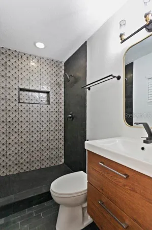 a bathroom with a sink a toilet and shower
