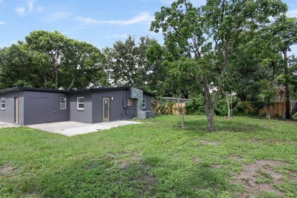 a front view of a house with a yard and trees