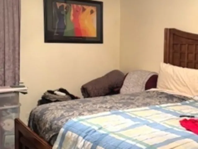 a bedroom with a bed and painting on the wall