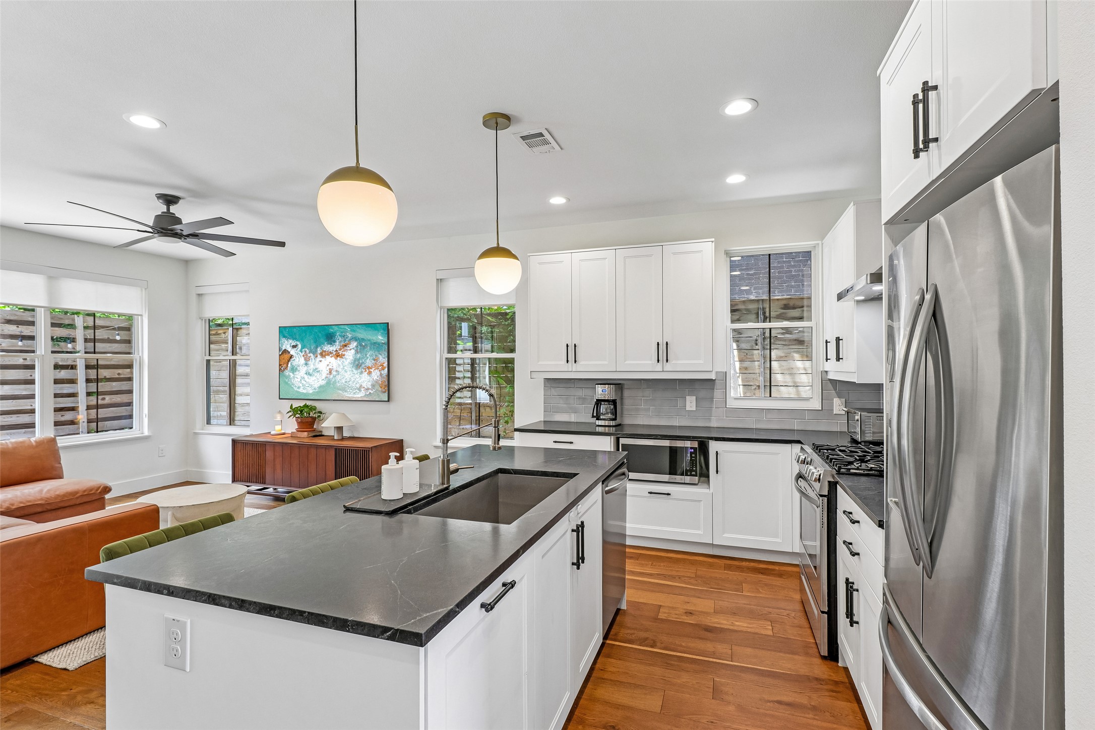 1706 Perez Street, Unit 1 Austin, TX 78721 - Photo 13 of 36 A contemporary kitchen and living area, complete with a generous island and sleek appliances, offers comfortable, open-concept living.
