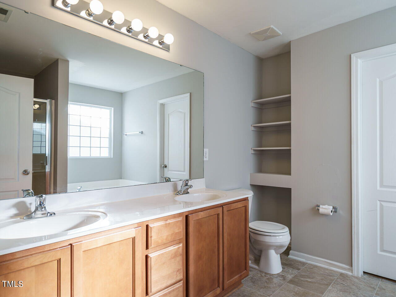 3709 Madeline Way Raleigh, NC 27610 - Photo 22 of 29 a bathroom with a granite countertop sink a toilet and a large mirror