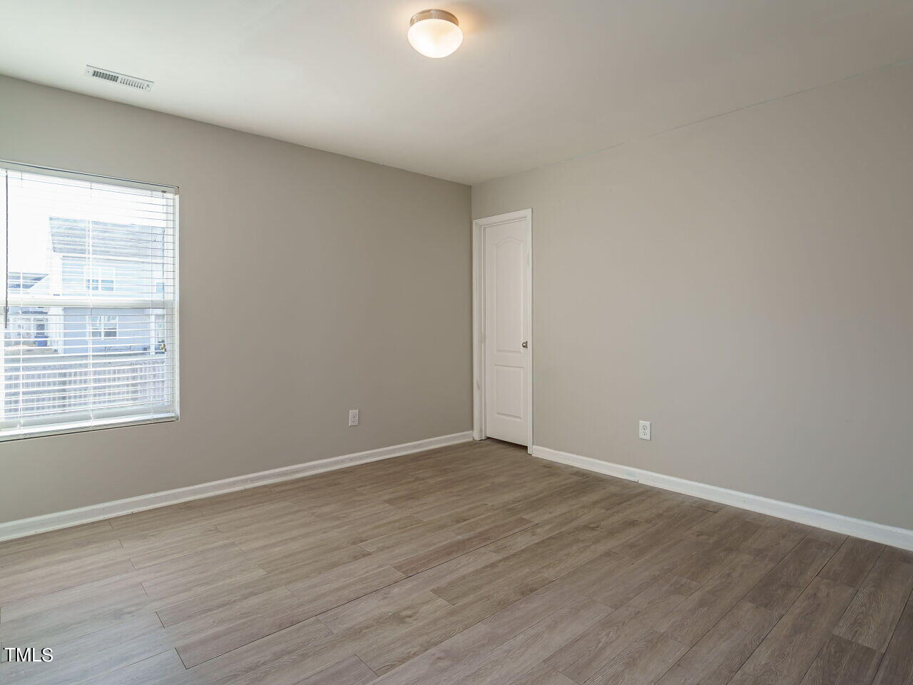3709 Madeline Way Raleigh, NC 27610 - Photo 27 of 29 a view of an empty room with wooden floor and a window