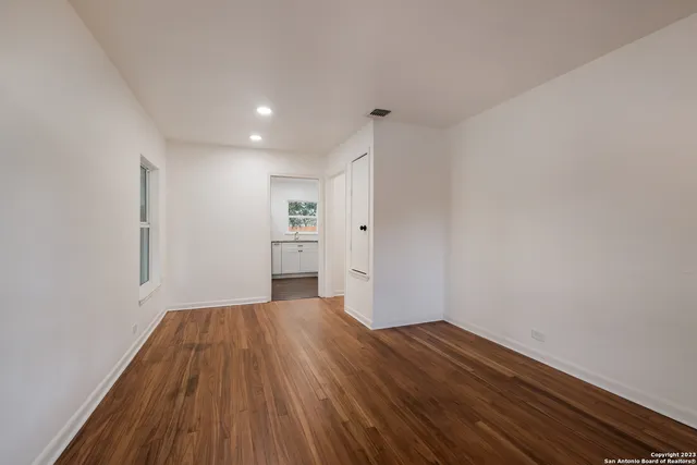 a view of a room with wooden floor and an entrance