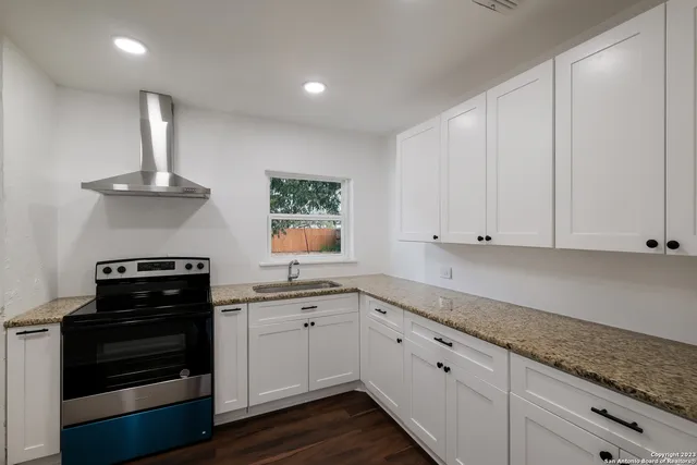 a kitchen with white cabinets and black appliances